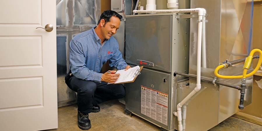 Trane technician inspecting heater
